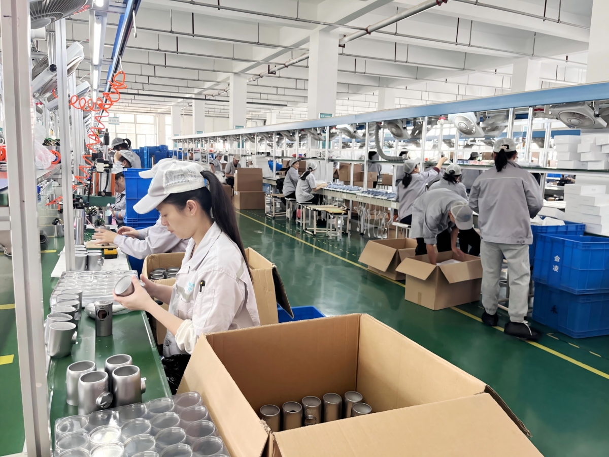 Workers assembling hair dryers on a factory production line