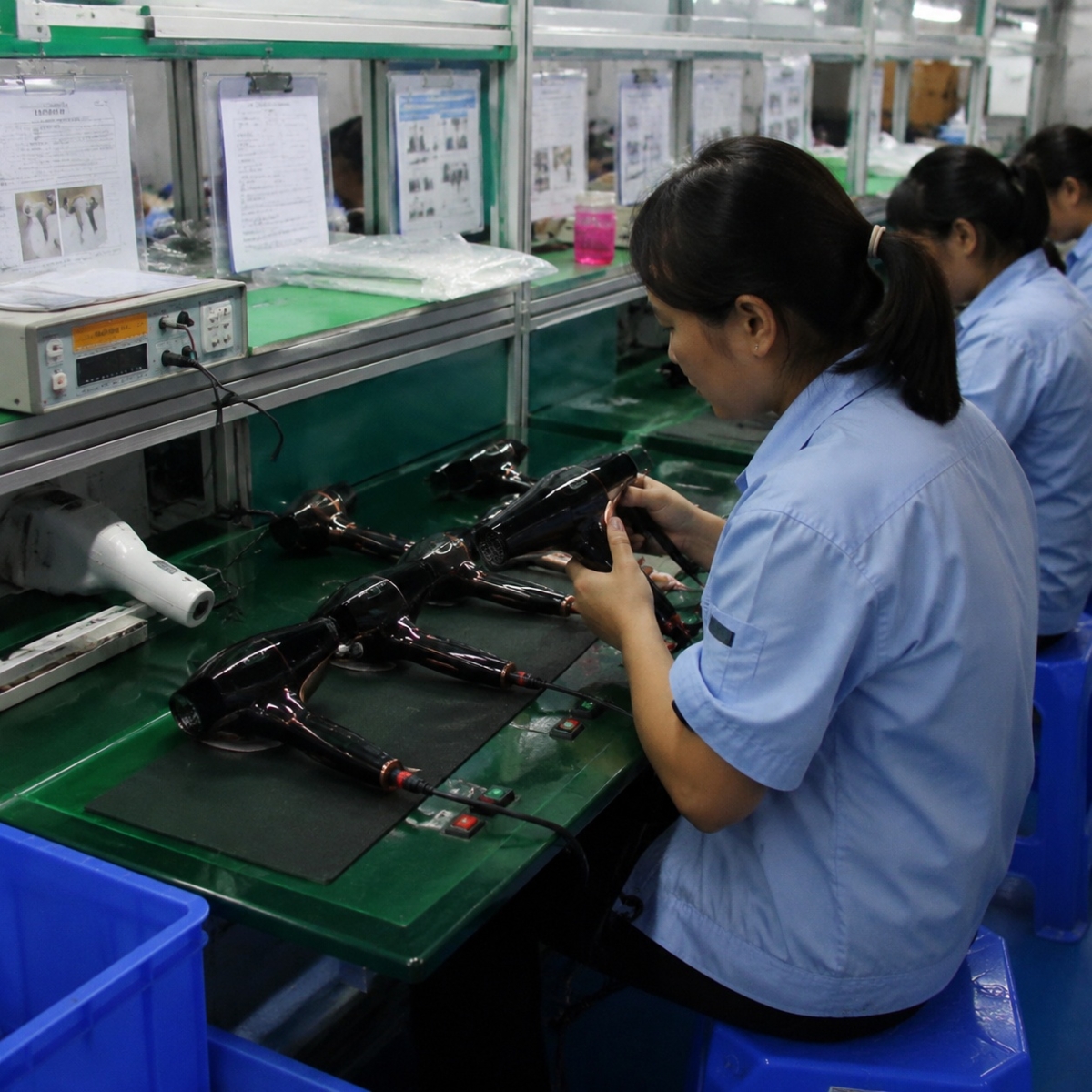 Worker assembling hair dryer components on a production line