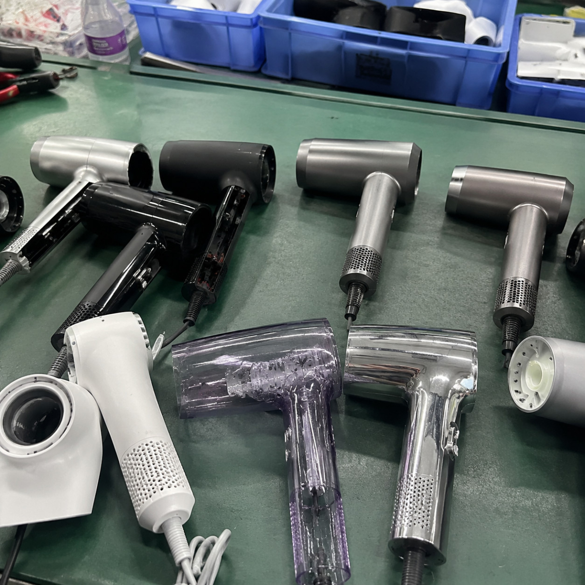 Hair dryer components and sample products on a factory table